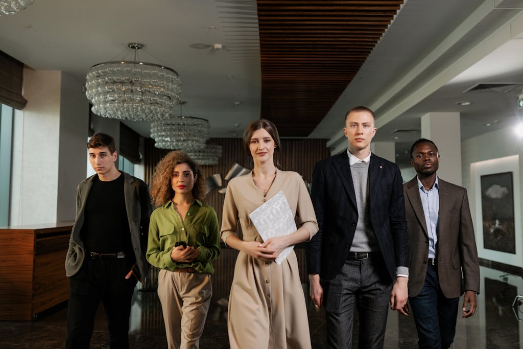A diverse group of professionals confidently walking through a stylish office environment.
